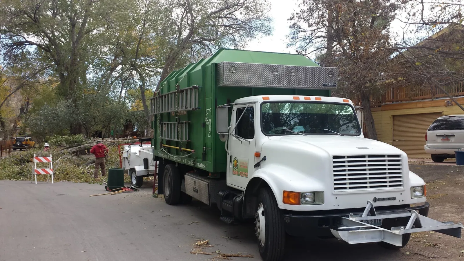 Vegas Best Tree Service dump truck on a tree-lined street during a cleanup